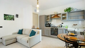 A modern kitchen with a dining area, including a sofa and a table set for dining. - Holiday Home 'Pullin' with Private Garden and Wi-Fi (Carasco)