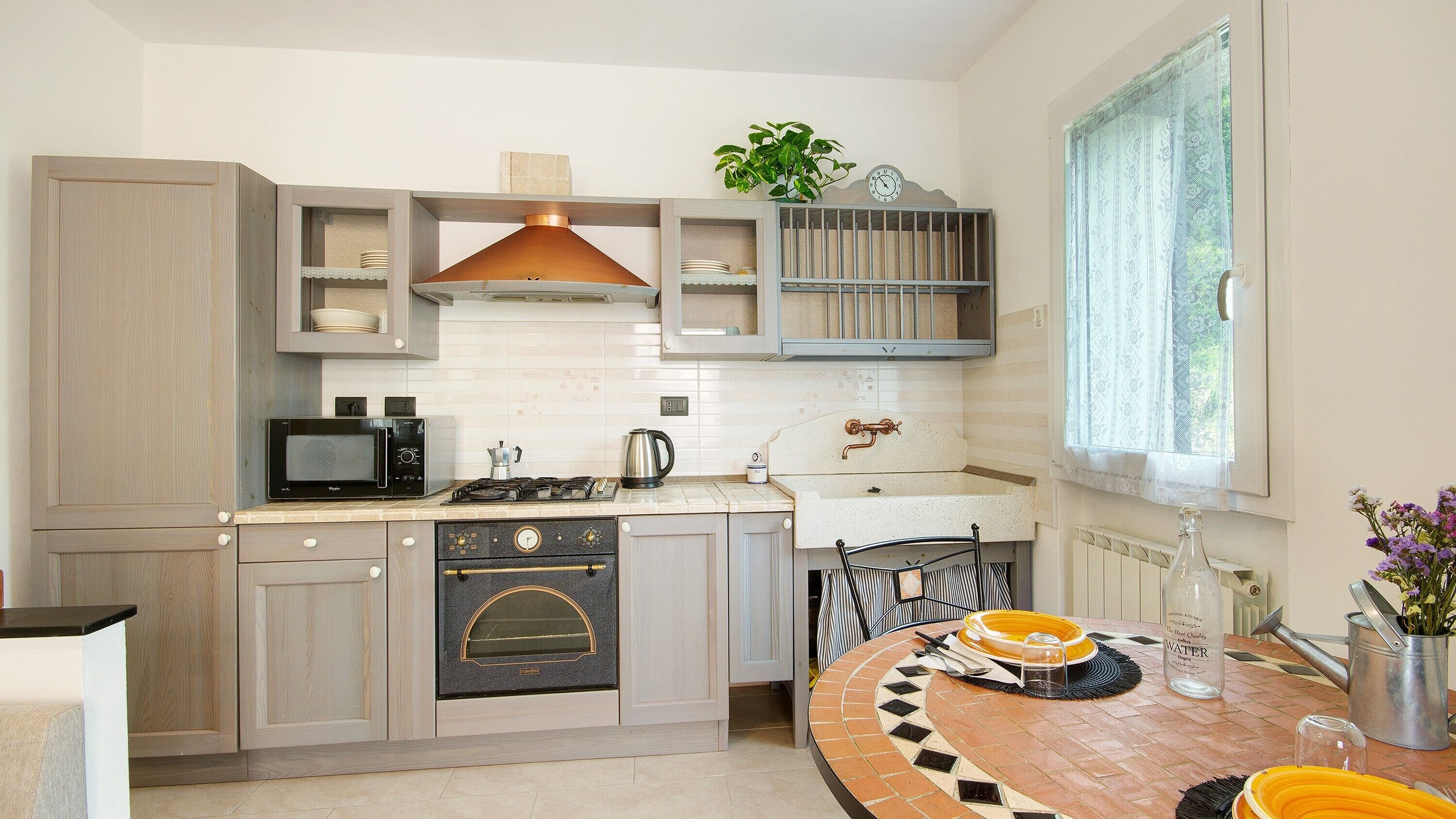A modern kitchen with a microwave, stove, oven, and a dining area with a round table.