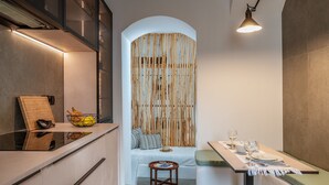 Une cuisine moderne équipée d’une cuisinière intégrée, d’une planche à découper en bois et d’un saladier rempli de fruits.