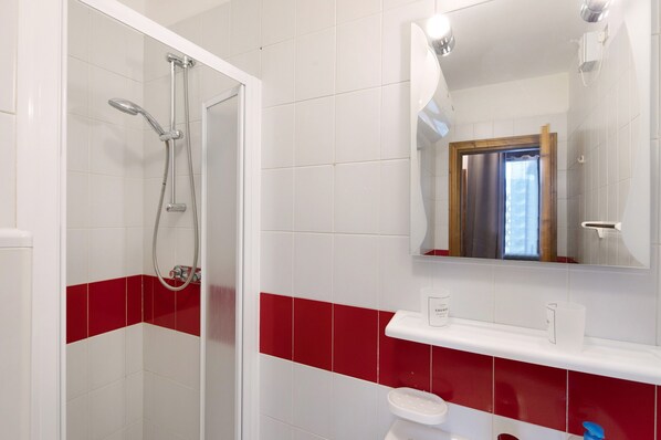 A bathroom with a shower, toilet, and sink.