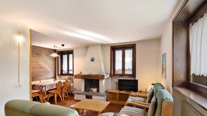 Una sala de estar acogedora con chimenea, muebles de madera y un televisor.