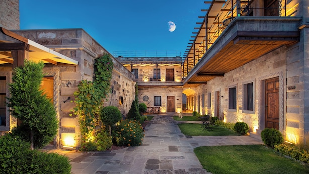 A courtyard with stone pathways, a wooden pergola, and a moon in the sky. - Woox Cappadocia Hotel (Nevsehir)