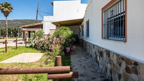 A narrow stone pathway leading to a building with a wooden bench in the foreground.