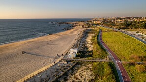 Una carretera costera con una playa a un lado y un paisaje urbano al otro.