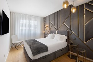 Une chambre moderne avec un lit, une chaise, un téléviseur et un décor mural original.