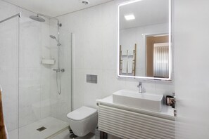 Une salle de bain moderne équipée d’une douche, de toilettes et d’un lavabo.