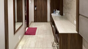 Un pasillo moderno con techo de madera, suelo de mármol y un banco empotrado.