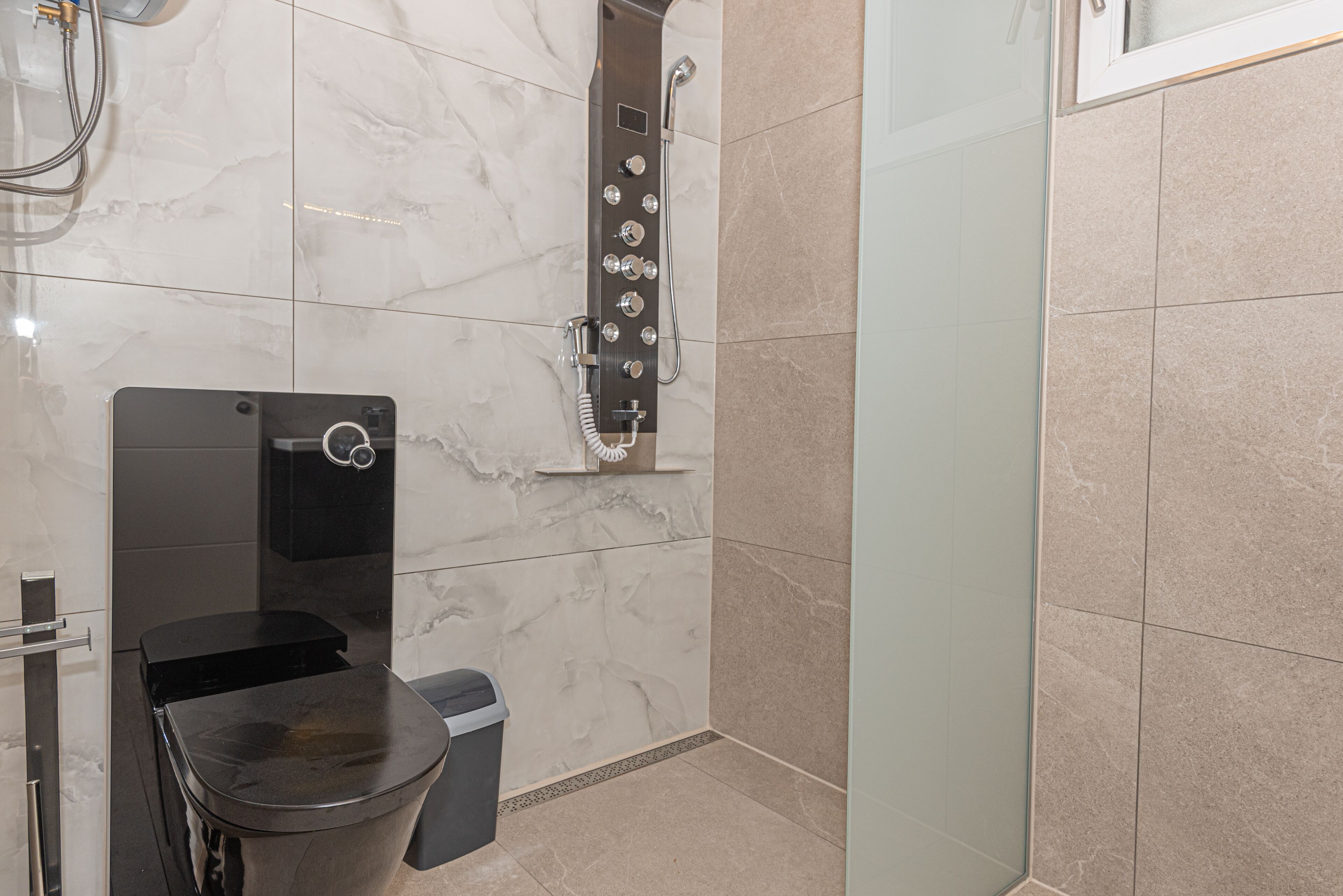 Un baño moderno con inodoro, bidé y ducha.