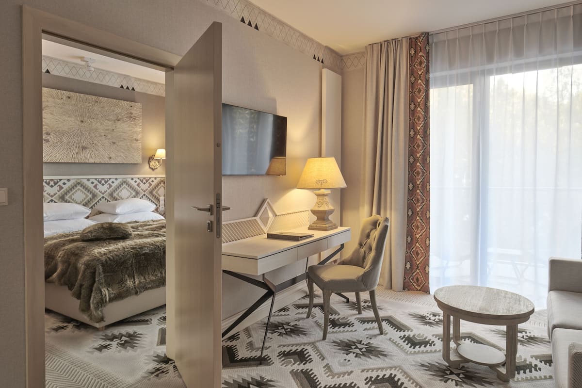Una habitación de hotel con cama, escritorio, silla y mesa redonda.