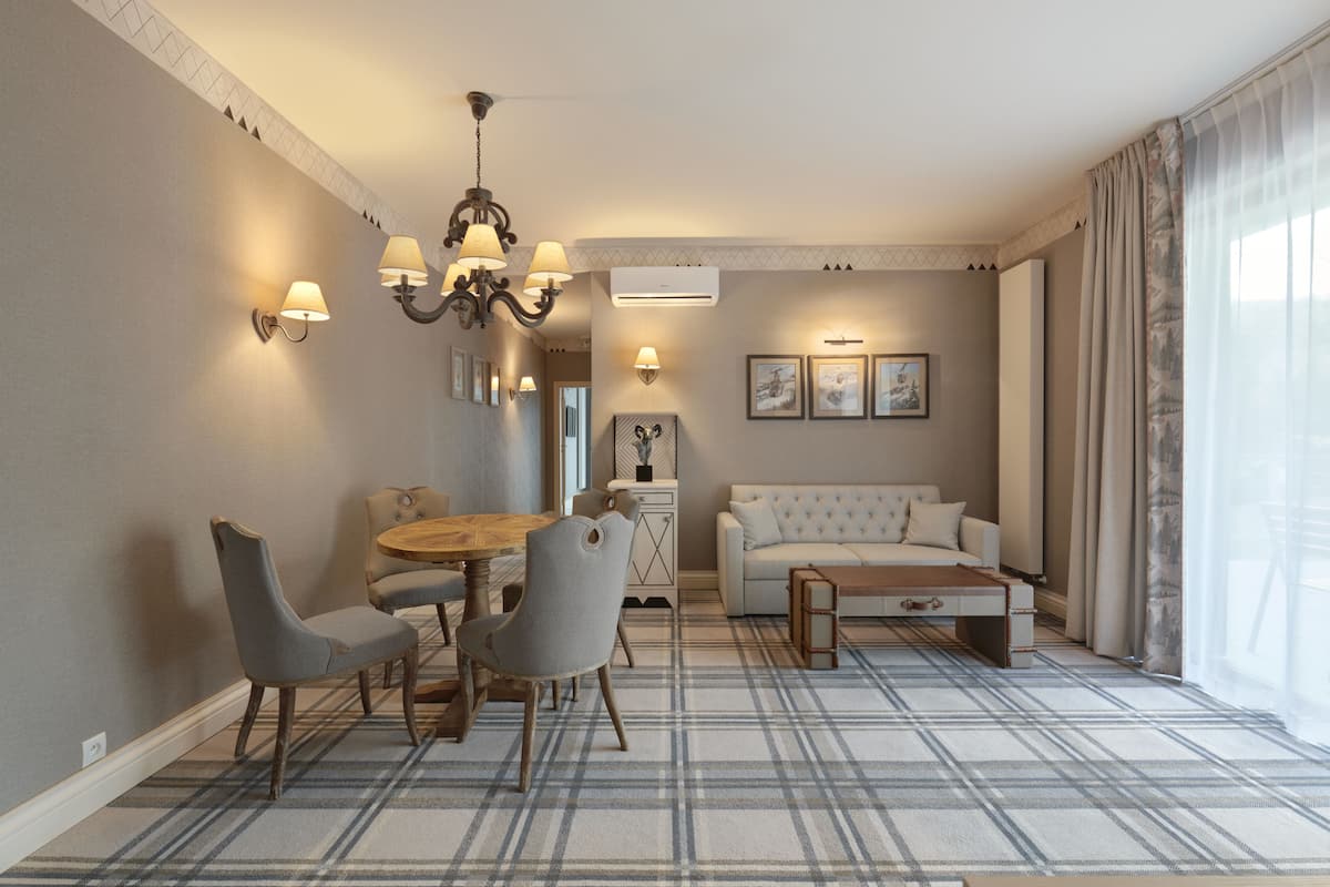 Una sala de estar moderna con comedor, que incluye una araña, un sofá y una mesa de centro.