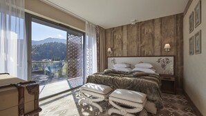 Un dormitorio con un amplio ventanal, una cama con cabecero estampado y vistas al exterior.