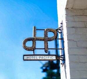 A hotel sign with a distinctive design and the name "HOTEL PACIFIC" displayed below it.