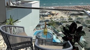 Un balcón con dos sillones de mimbre, una mesita y una planta en maceta.