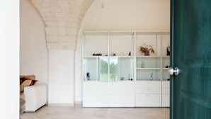 Un interior moderno con un armario blanco, un sofá beige y una puerta verde.