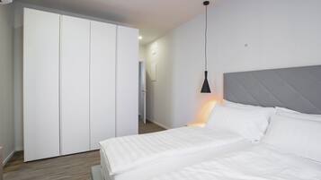 Ein Schlafzimmer mit Bett, Kleiderschrank und einer Pendelleuchte.