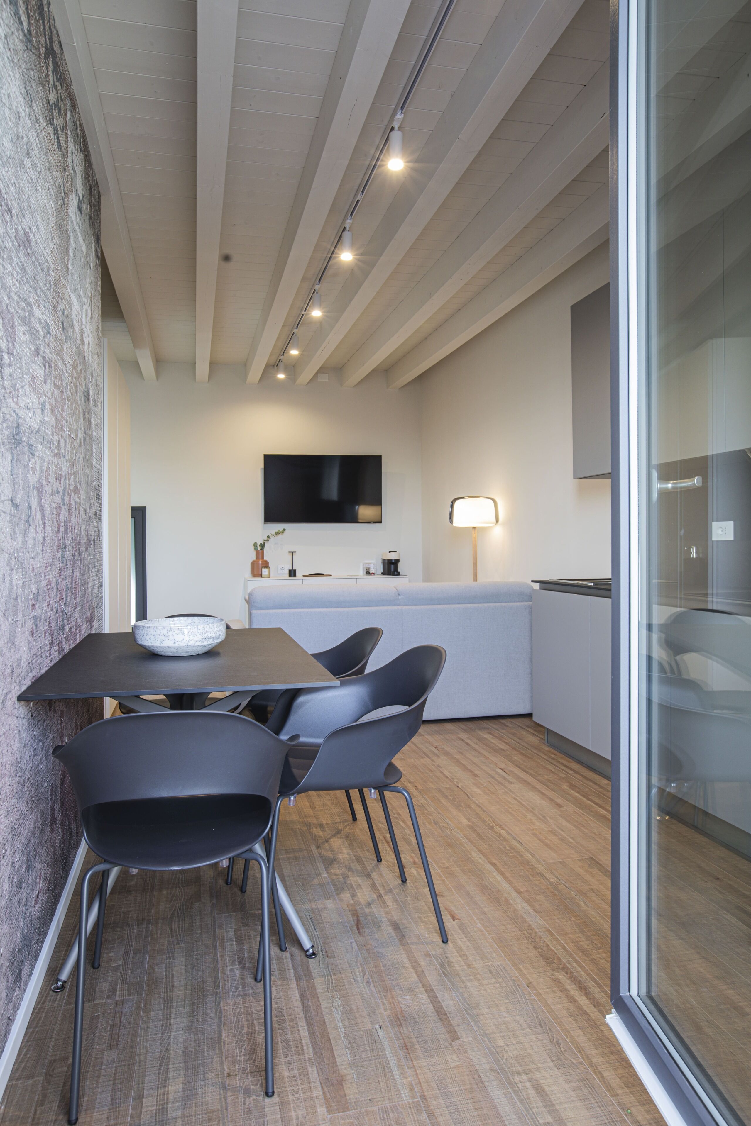 A modern kitchen with a dining area, featuring a large table, chairs, and a bowl on the table.