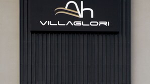 A sign with the text "VILLAGLORI" on a black background with a stylized 'h' above the text. - Ah Villa Glori Brescia (Brescia)