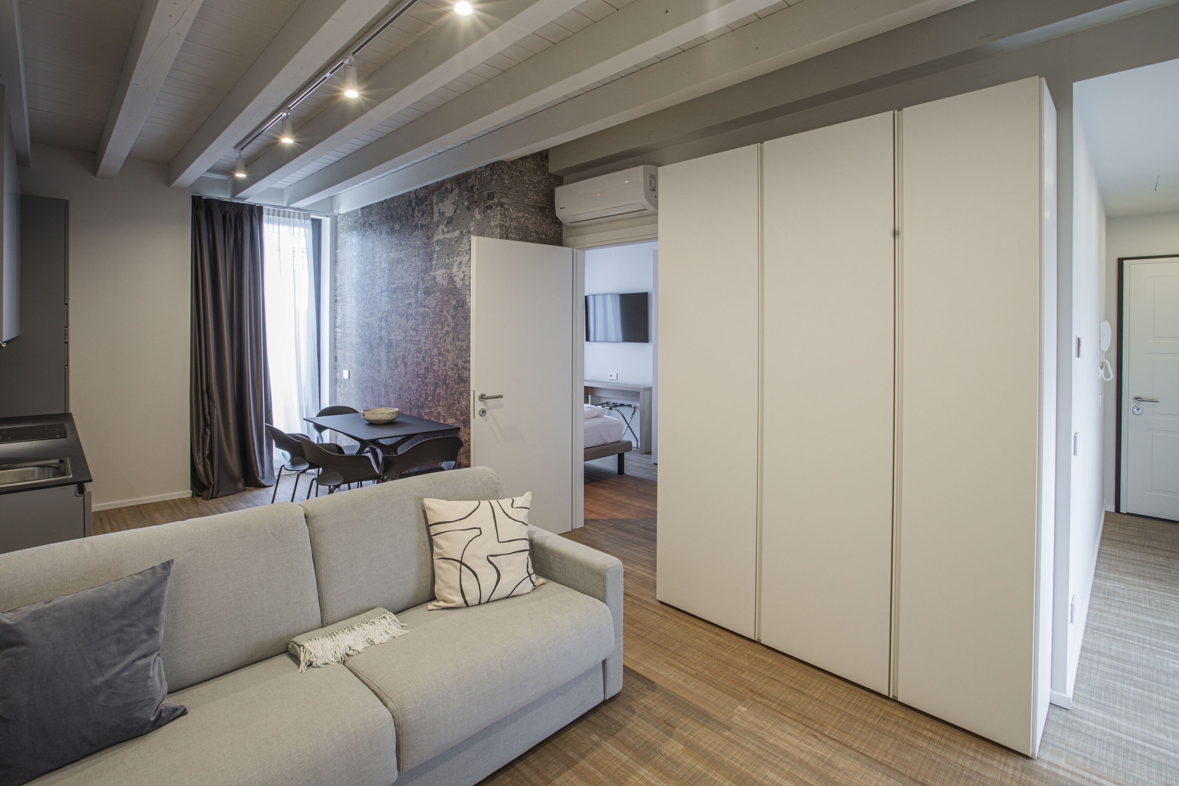 Una sala de estar moderna con un sofá, una mesa de comedor y una zona de cocina.