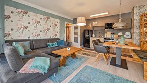 Un salon moderne avec un canapé, une table basse et un coin repas.