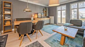 Un salon moderne comprenant un coin repas, une grande fenêtre ornée de vitraux et une vue sur la ville.