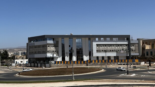 A modern building with a symmetrical facade, large windows, and a central entrance.