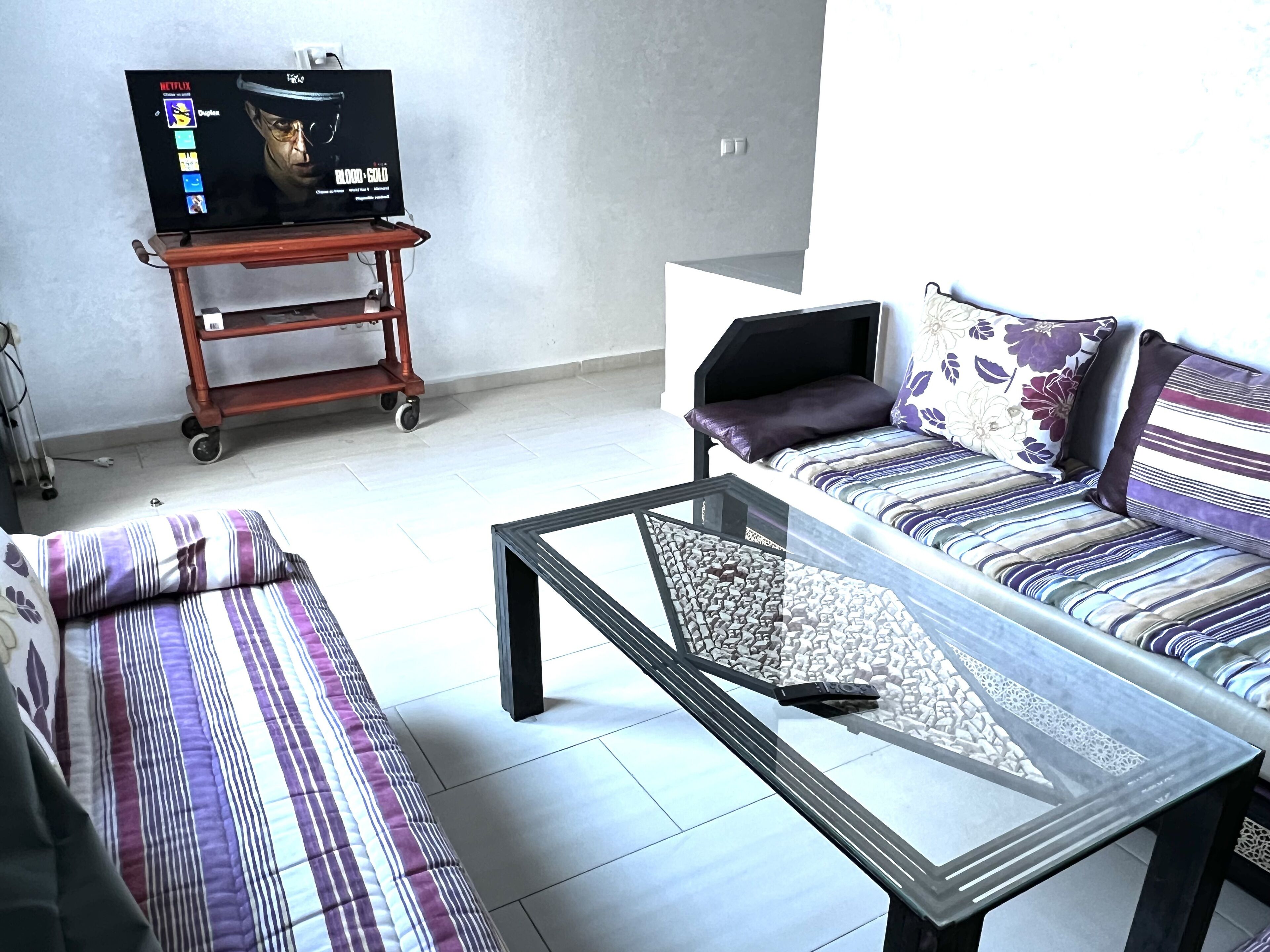 A living room with a sofa, a coffee table, and a TV on a stand.
