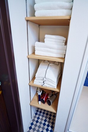 Towels and essentials are neatly stored on multiple shelves.
