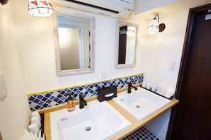 Bathroom features two sinks, a mirror above each, and a mosaic tile border.