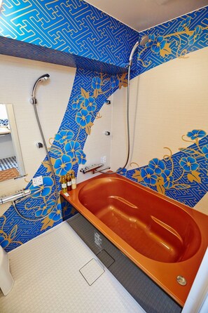 Bathroom features a large oval-shaped bathtub, a white sink, and a shower with a blue and gold patterned shower curtain.