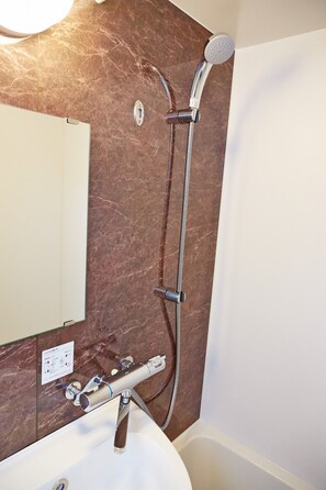 Bathroom features a handheld showerhead, sink, and bathtub.
