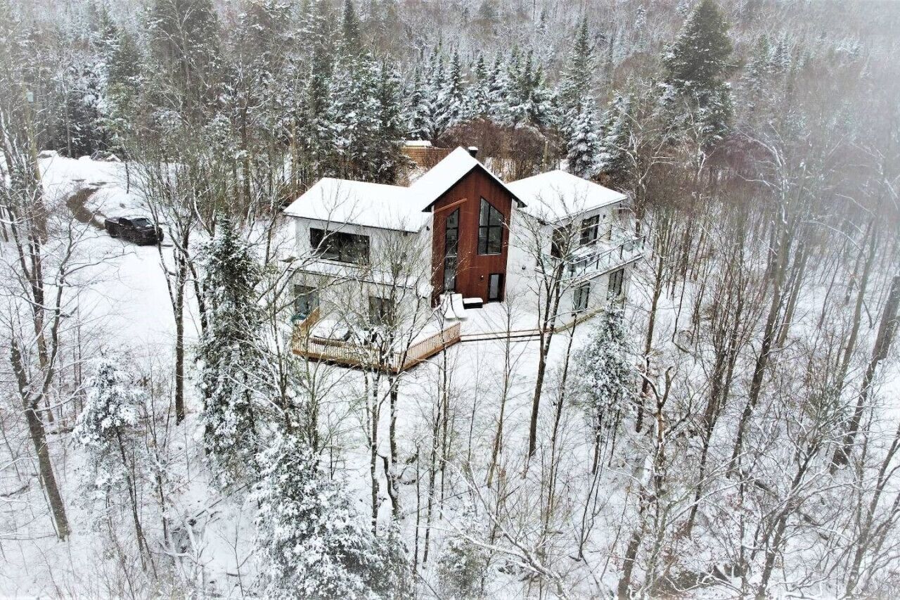 Una cabaña rodeada de árboles cubiertos de nieve.