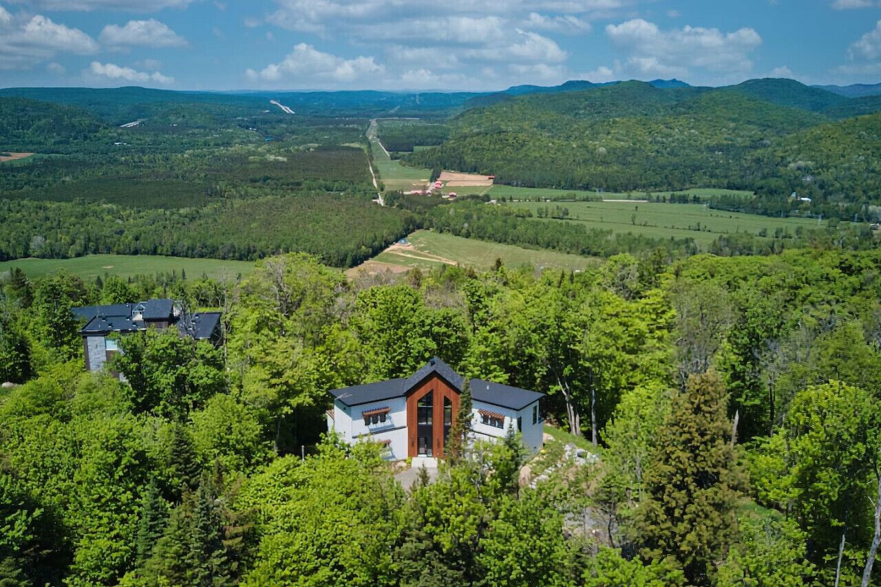 Una casa rodeada de un bosque frondoso, con una vista despejada del paisaje circundante.