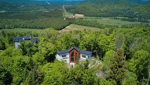 Ein Haus, umgeben von dichtem Wald, mit freiem Blick auf die umliegende Landschaft.