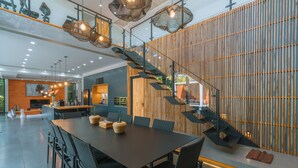 Un interior moderno con comedor, cocina y escalera.