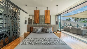 Un dormitorio moderno con una cama grande, cabecero de madera y vistas al exterior.