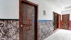 A hallway with patterned walls and wooden doors. - OYO Life 91060 Villa Wijaya Homestay (Prigen)