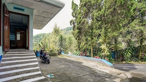 A paved pathway leading to a building with a motorcycle parked nearby. - OYO Life 91060 Villa Wijaya Homestay (Prigen)