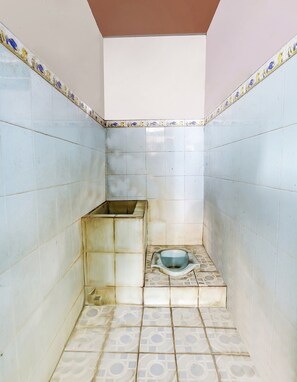 A small, tiled bathroom with a toilet and a sink. - OYO Homes 91151 Desa Wisata Kreatif Perdamaian Srumbung Gunung (Bawen)