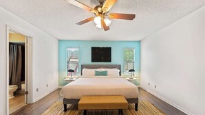 A bedroom with a bed, a ceiling fan, a window, and a door. - *True Blue Pool Oasis* ping-pong, wi-fi, tv (Jacksonville)
