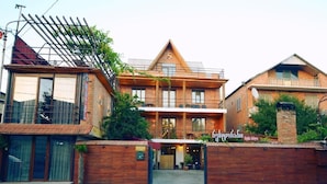 A two-story building with a wooden facade, large windows, and a balcony. - chveni sakhli (Tbilisi)