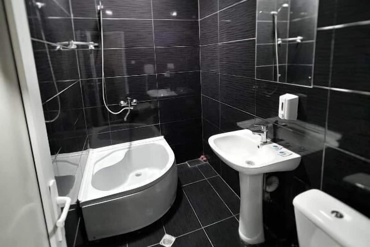 Ein modernes Badezimmer mit Badewanne, Waschbecken und Toilette.