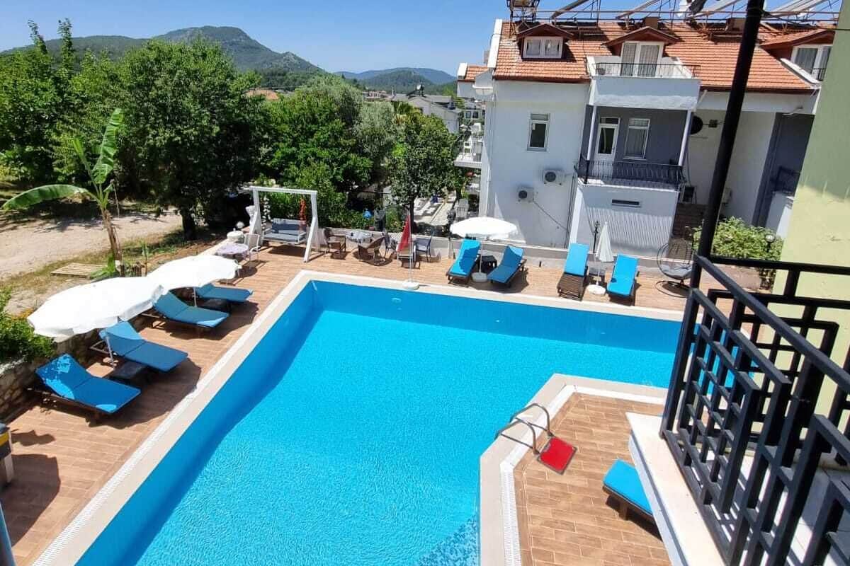A rectangular swimming pool with blue water, surrounded by lounge chairs and umbrellas.