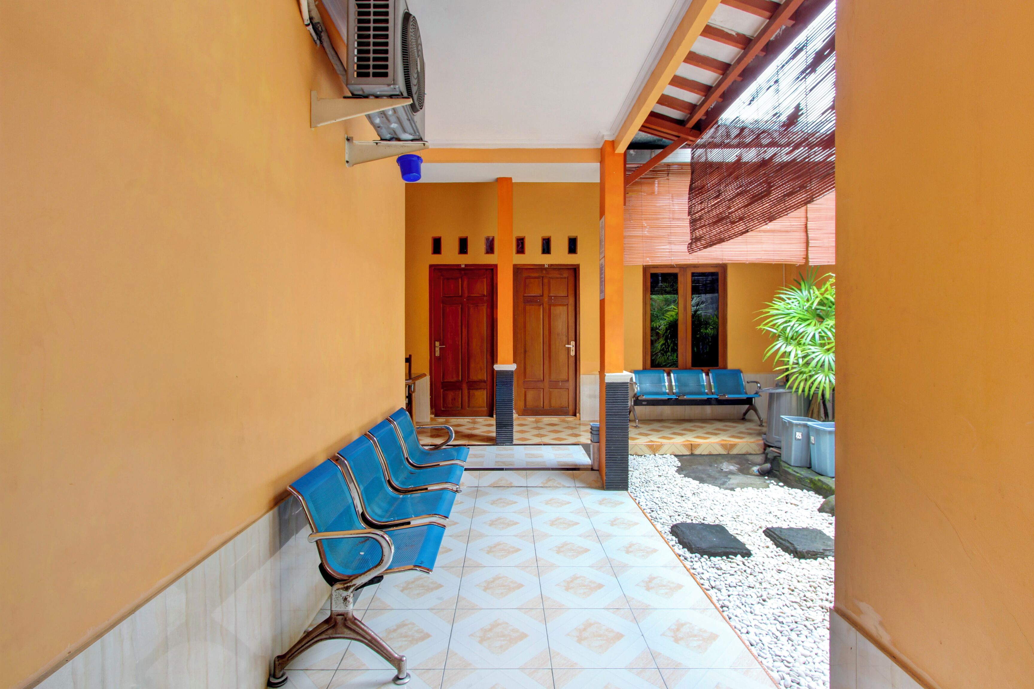 A waiting area with blue chairs, a small table, and a potted plant.