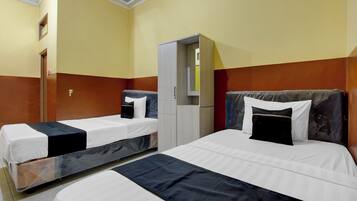 Quarto de hotel com duas camas, um guarda-roupa e um espelho.