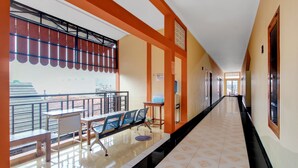 A hotel corridor with a bench, a table, and chairs, a railing, and a view of the outside. - Hotel O near Ahmad Dahlan University formerly Endrayanti Inn (Yogyakarta)