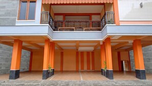 A two-story building with a balcony, columns, and a tiled entrance area. - Hotel O near Ahmad Dahlan University formerly Endrayanti Inn (Yogyakarta)