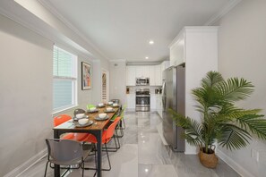 Enjoy meals in the kitchen and dining area, featuring a refrigerator, microwave, and oven, with a wooden table and comfortable seating.