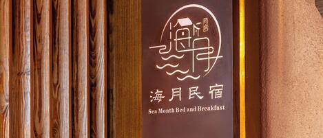 A sign with a nautical theme, featuring a boat and waves, and the text "Sea Month Bed and Breakfast".