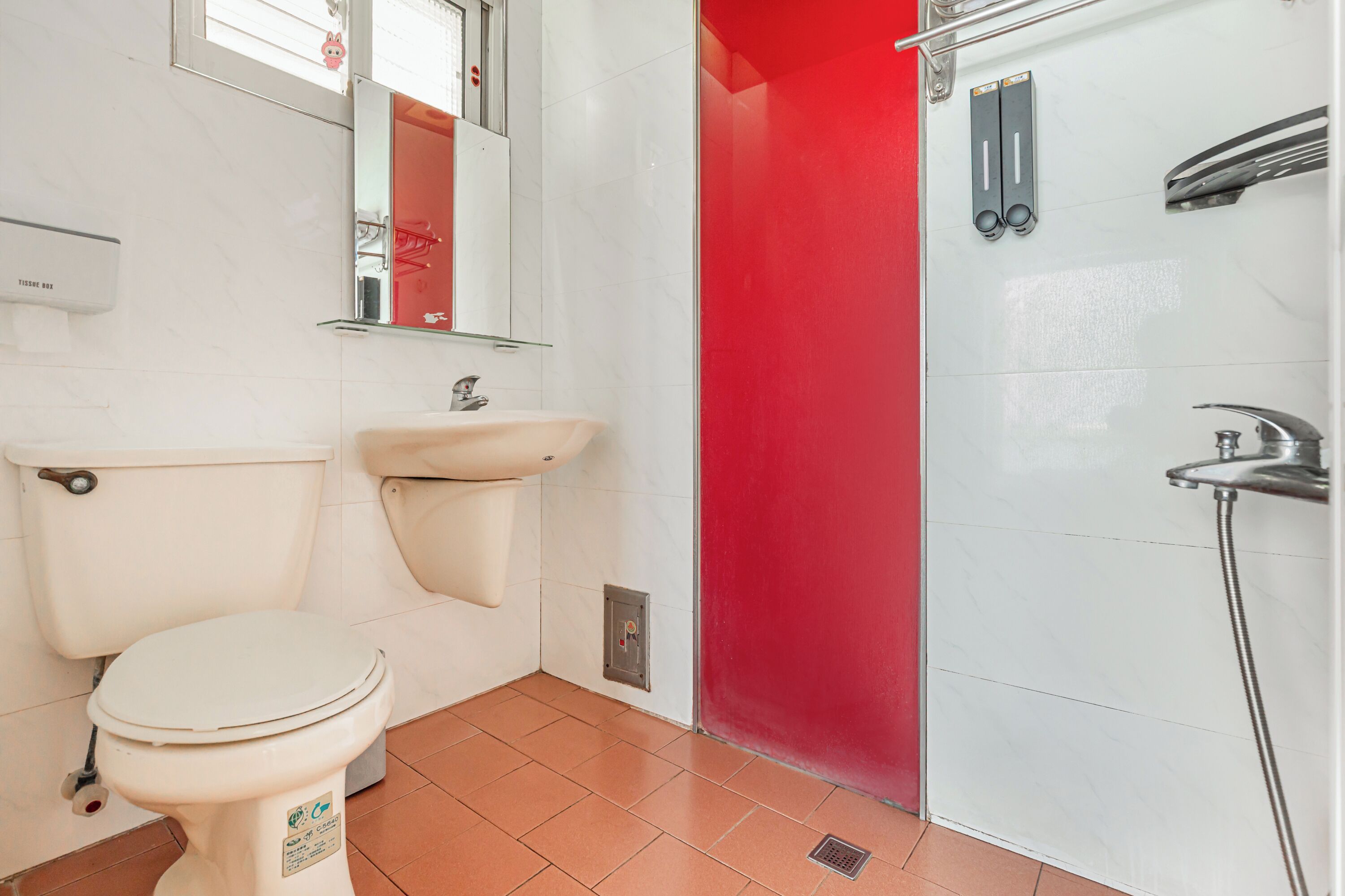 A bathroom with a toilet, sink, and shower.