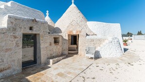 A stone building with a conical roof, a doorway, and a small window. - Trullo La Dolina by Wonderful Italy (Ostuni)